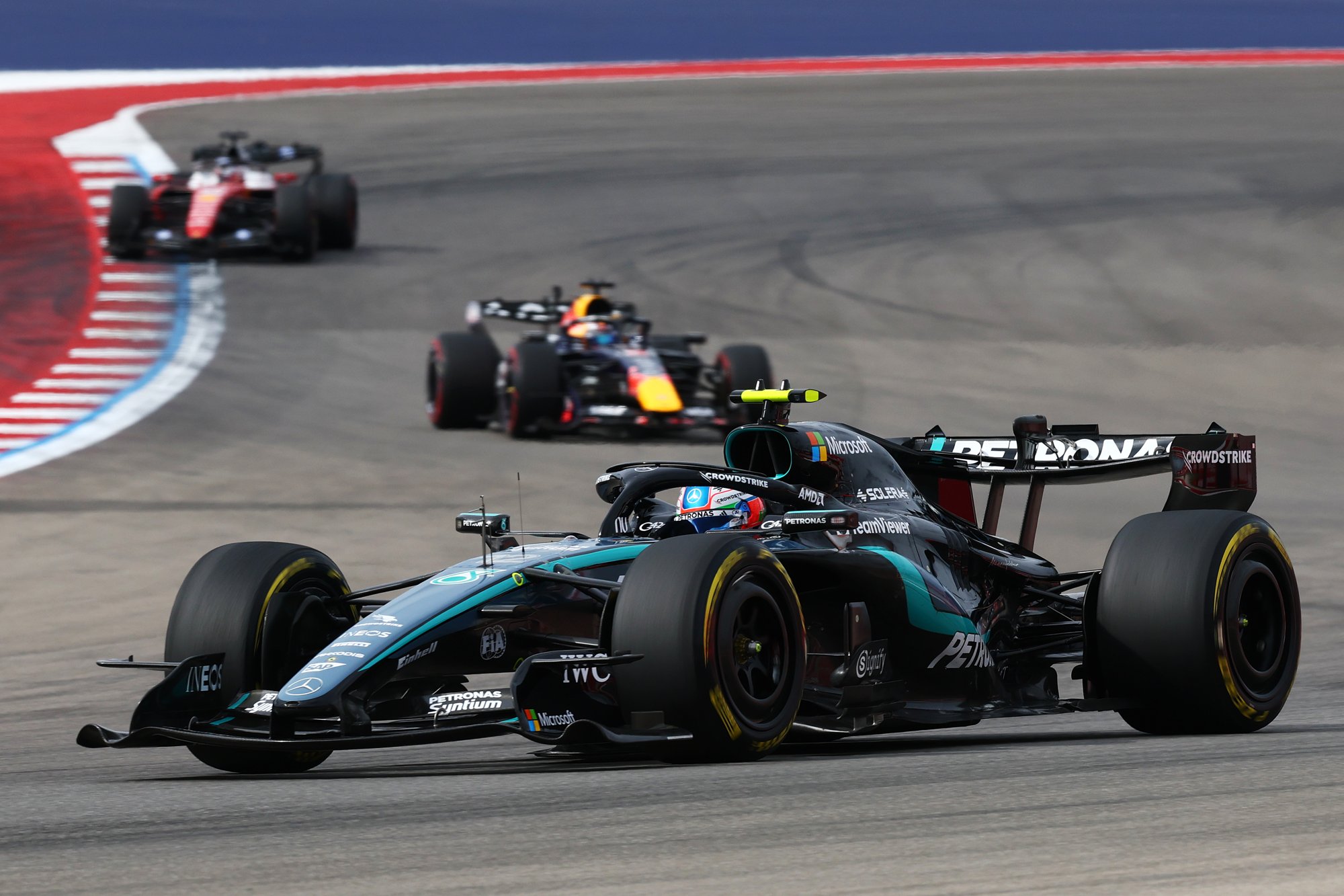 El Mercedes de Kimi Antonelli encabeza la carrera en una curva del Circuito de las Américas, seguido por un Red Bull y un Ferrari.