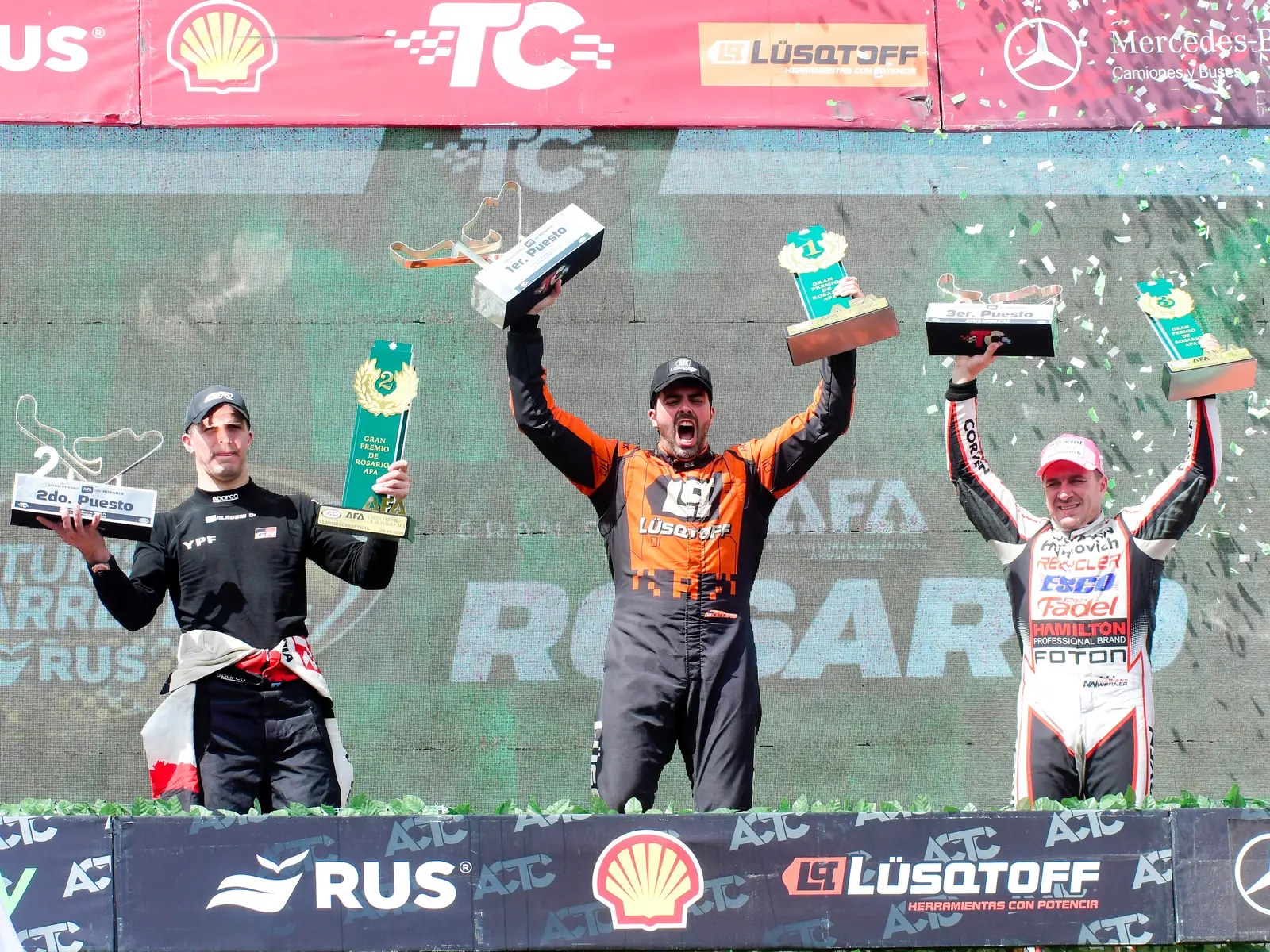 Mauricio Lambiris levanta el trofeo en lo alto del podio de Rosario, junto a Matías Rossi y Mariano Werner