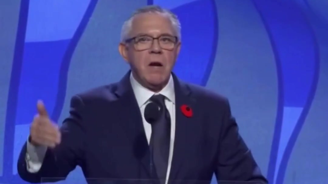 Lorne Doerkson habla en el atril durante su discurso de la noche de la elección, ante un fondo azul