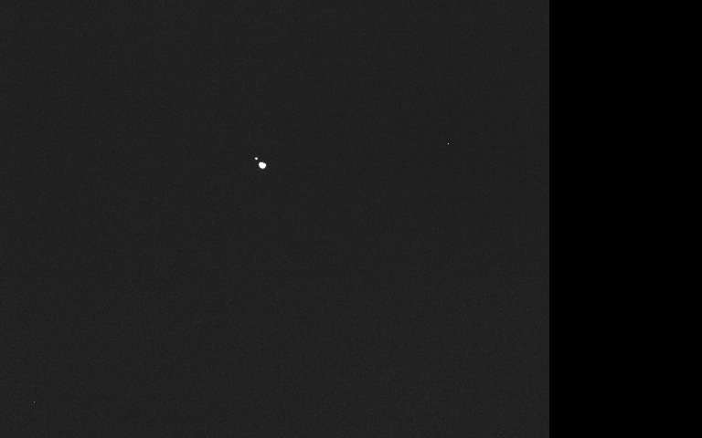 Imagen completa de la cámara de Hera: fondo oscuro con dos puntos brillantes muy juntos cerca del centro izquierdo.