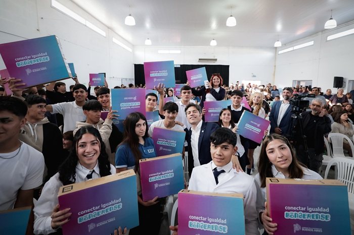 Kicillof rodeado de estudiantes secundarios que sostienen las cajas de las netbooks de Conectar Igualdad Bonaerense