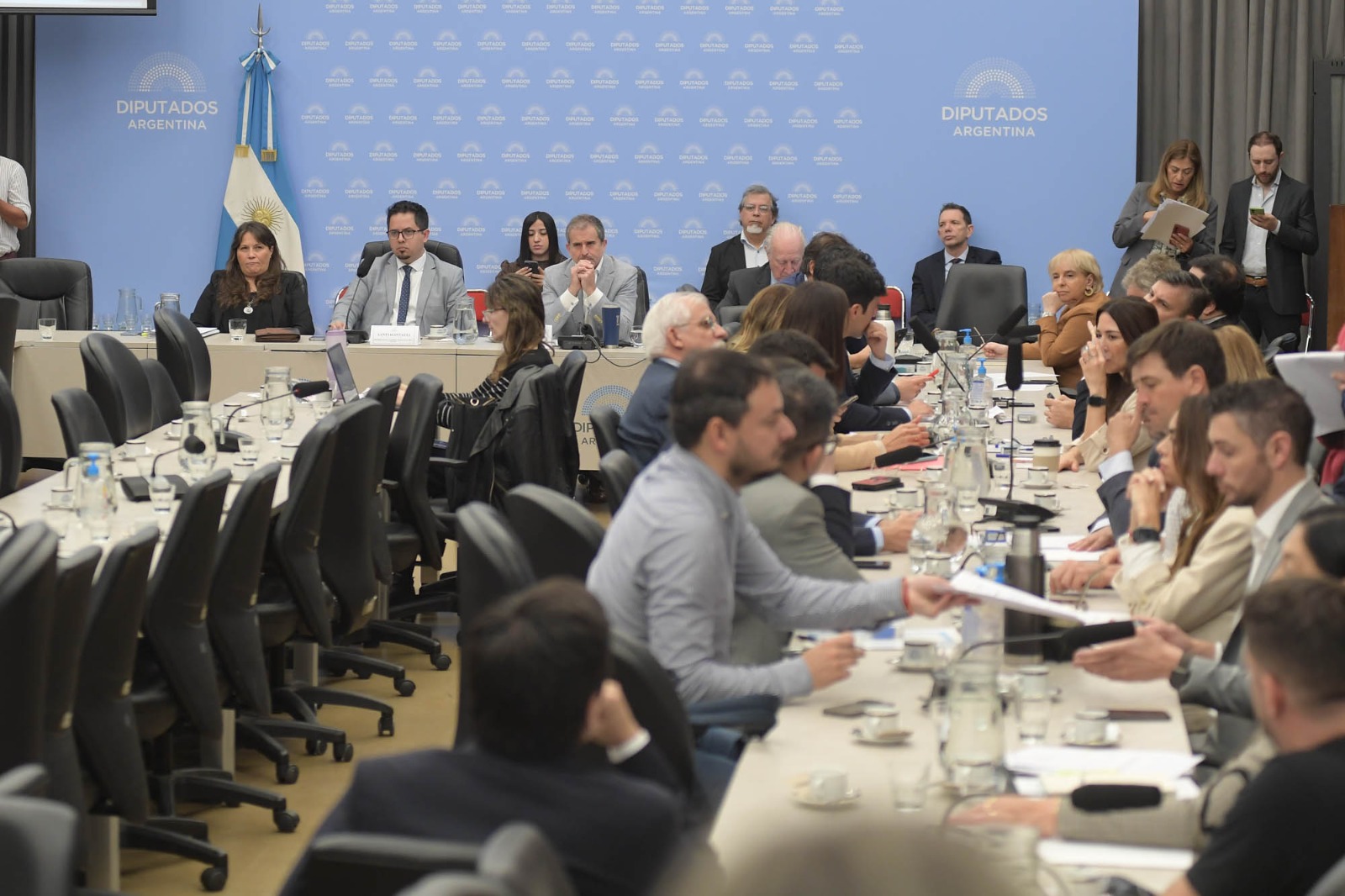 Diputados sentados alrededor de las mesas del plenario de las comisiones de Finanzas y de Presupuesto y Hacienda, en una sala del Congreso