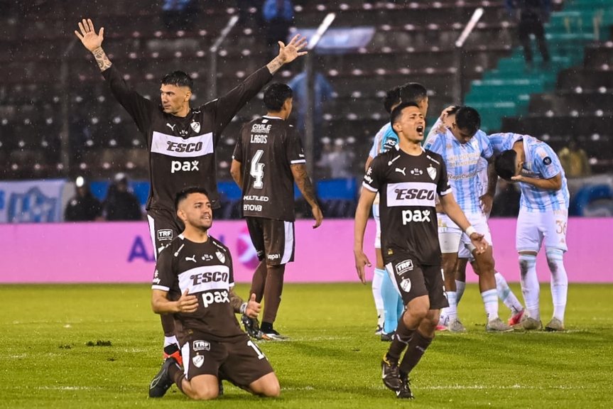Jugadores de Platense celebran el último penal mientras los de Atlético Tucumán se lamentan al fondo