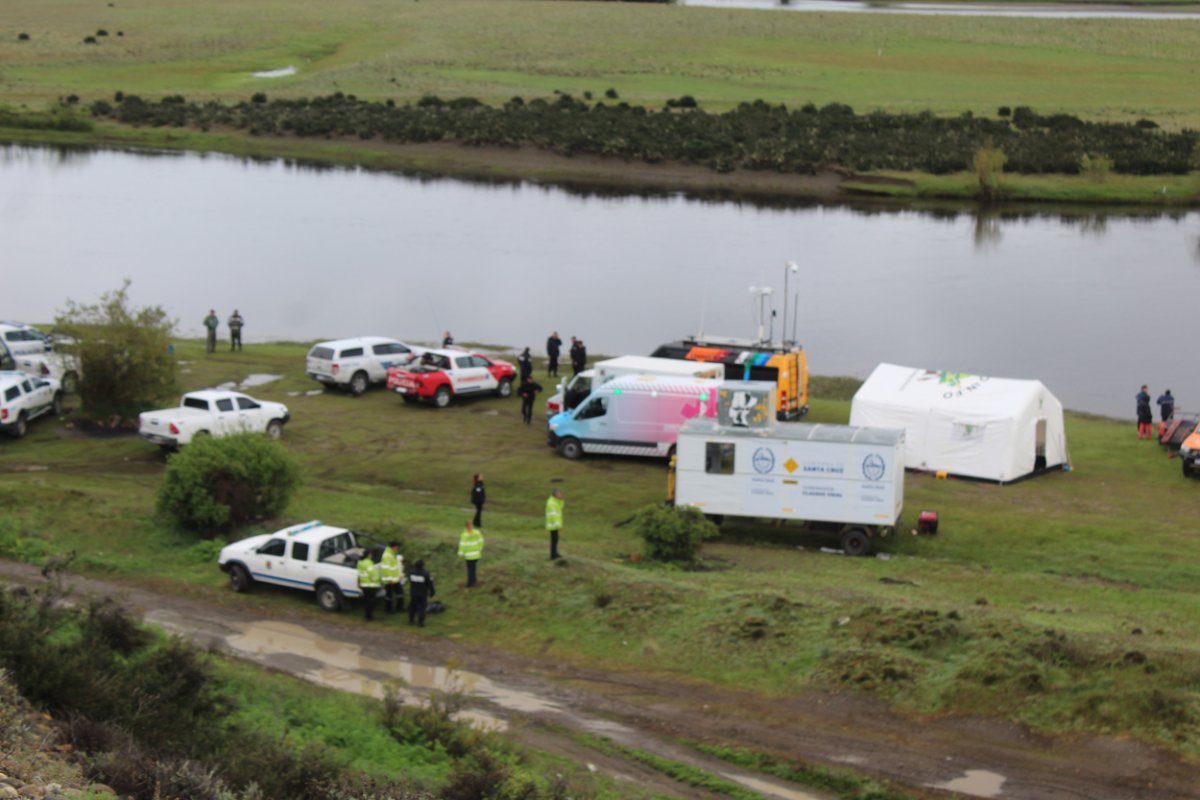 Vista aérea del campamento del operativo de búsqueda, con vehículos, carpas y personal junto al río Gallegos, en La Toma
