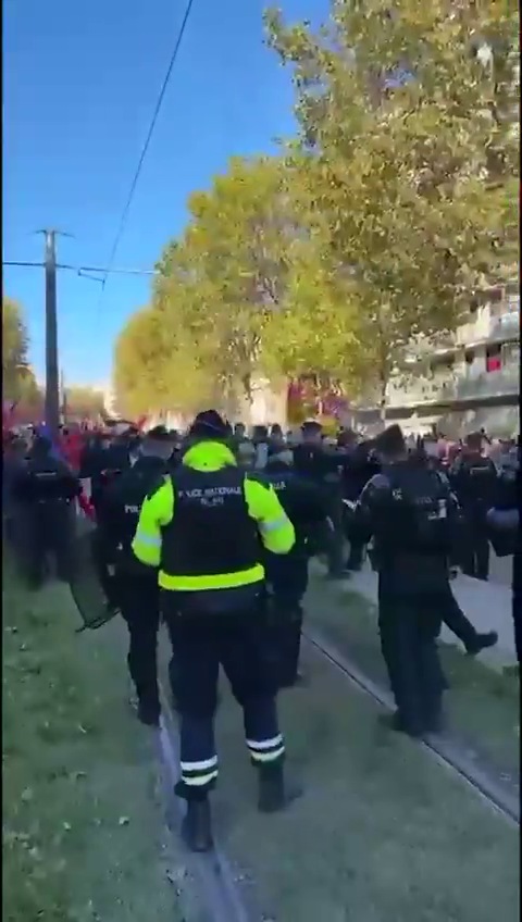 Manifestantes reunidos en un bulevar del este de París, frente a edificios y árboles, en un día de sol
