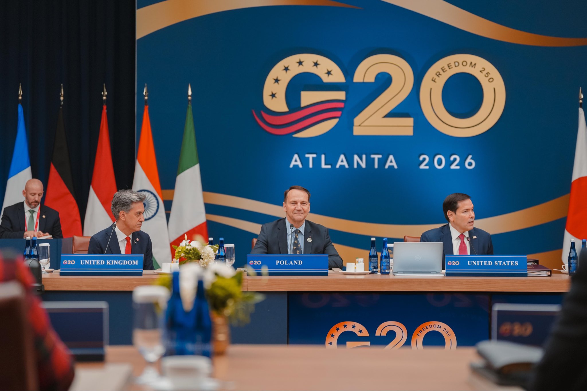 Ed Miliband, Radosław Sikorski y Marco Rubio sentados en la mesa del G20 frente al logo de Atlanta 2026